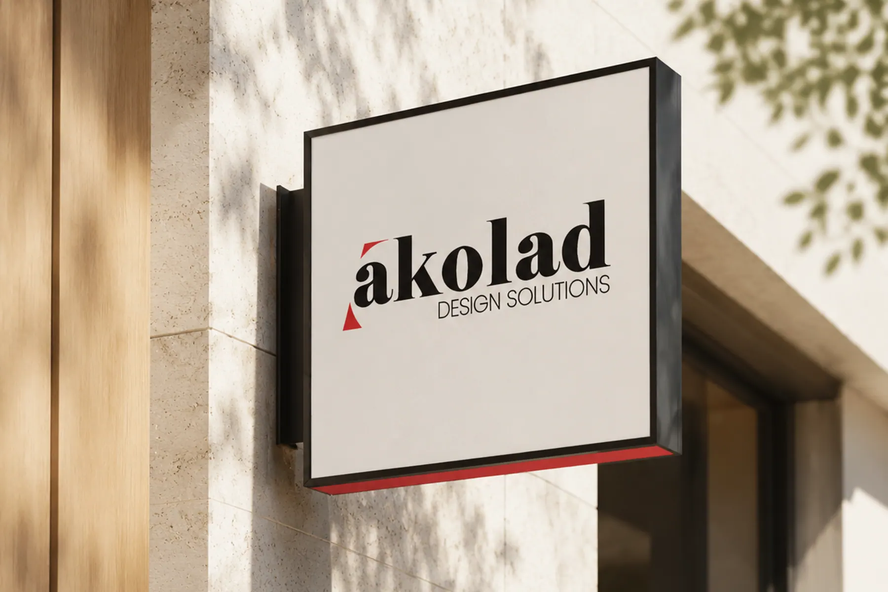 A projecting box sign on a stone facade, lit by afternoon sun with leaf shadows falling across the wall.